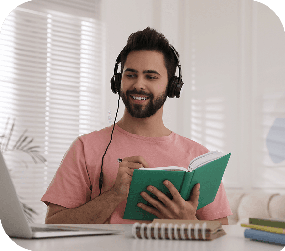 Teacher working with headphones while writing in a notebook